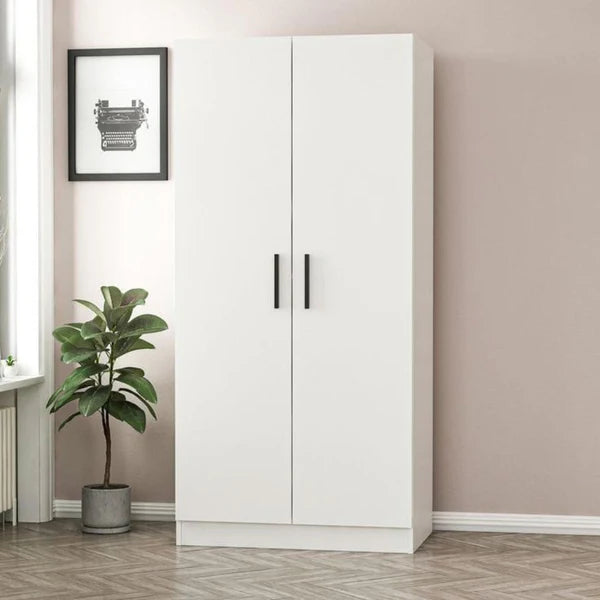 White wardrobe with black handles in a room with a plant and framed picture on the wall.