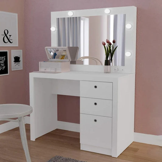 White vanity desk with illuminated mirror in a room with pink walls.