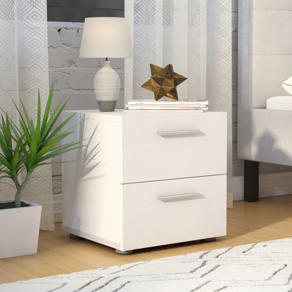 White nightstand with lamp and decorative items in a bedroom setting