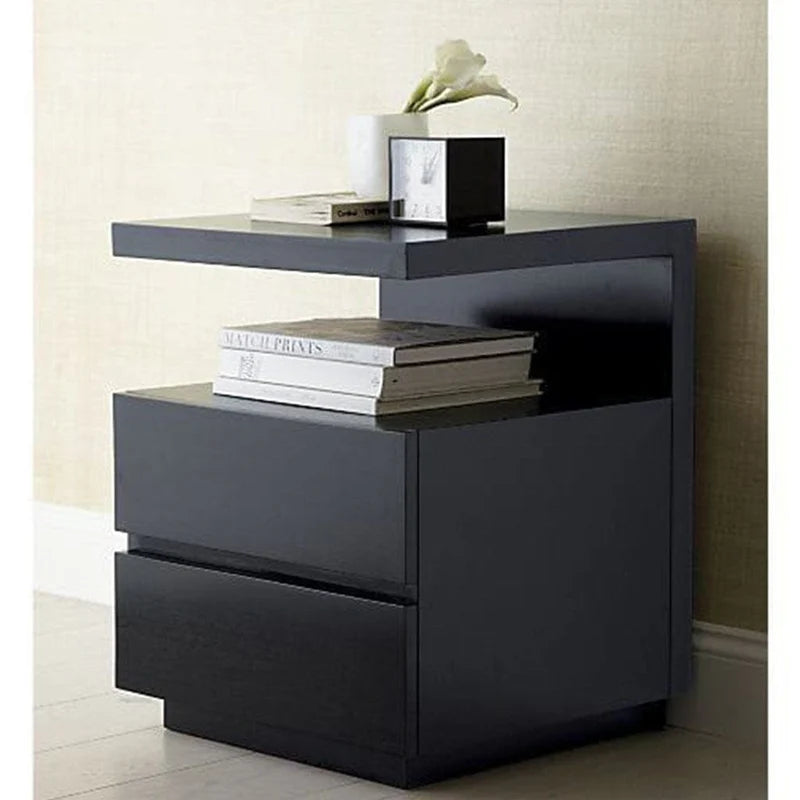 Black nightstand with two drawers and a small shelf, featuring books and a vase on top.