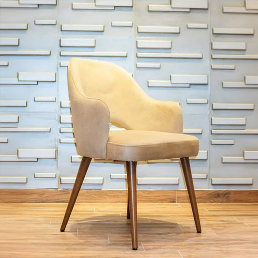 Beige chair with wooden legs against a decorative wall.