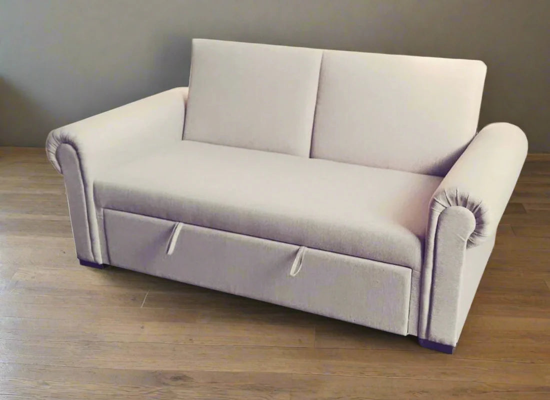 Gray sofa bed on a wooden floor with a plain wall background