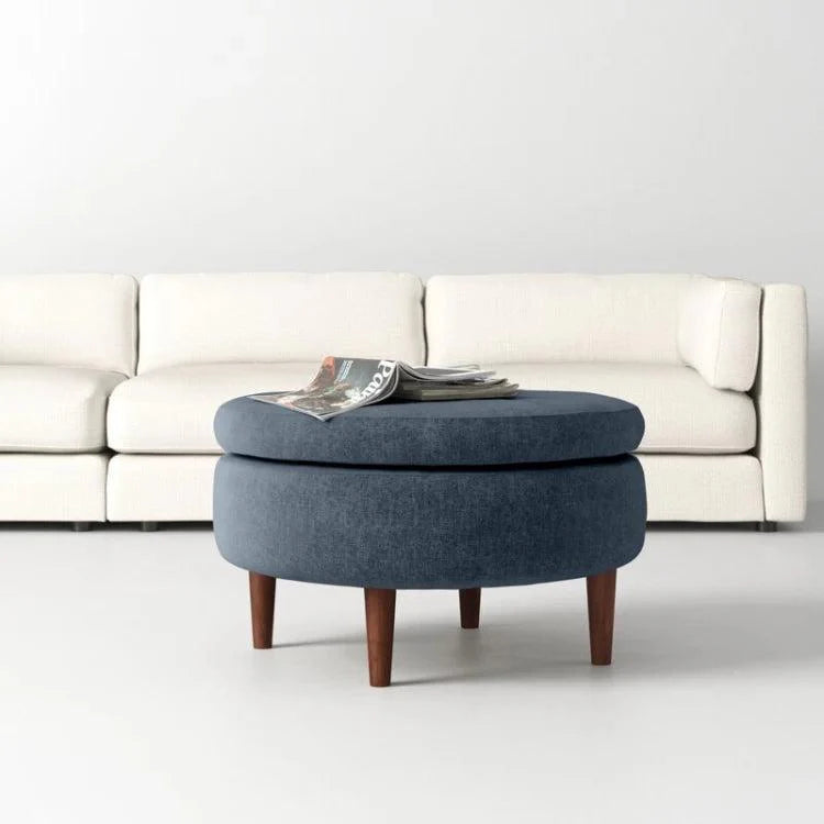 Blue ottoman with a white sofa in the background