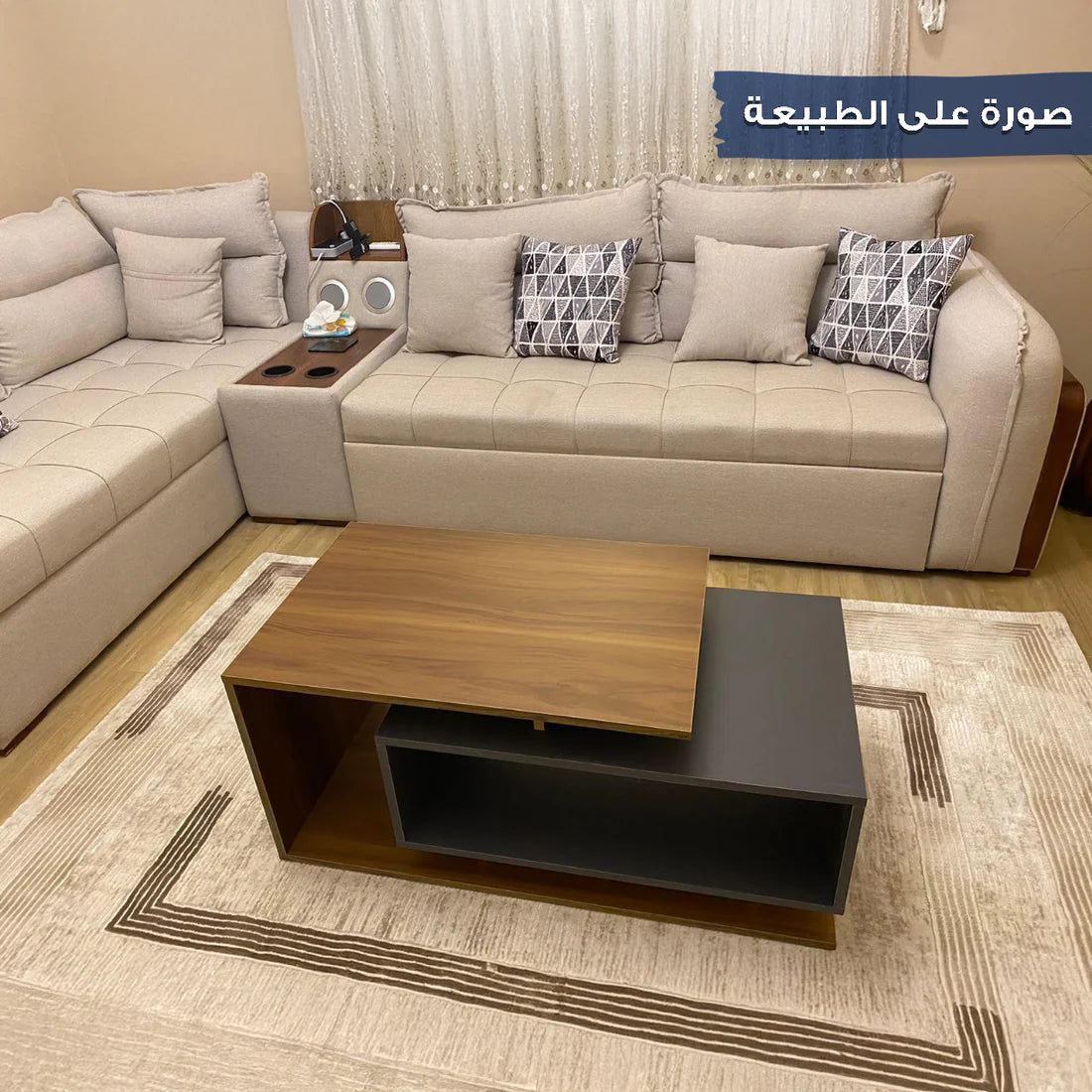 Beige sectional sofa with decorative pillows and a wooden coffee table in a living room setting.