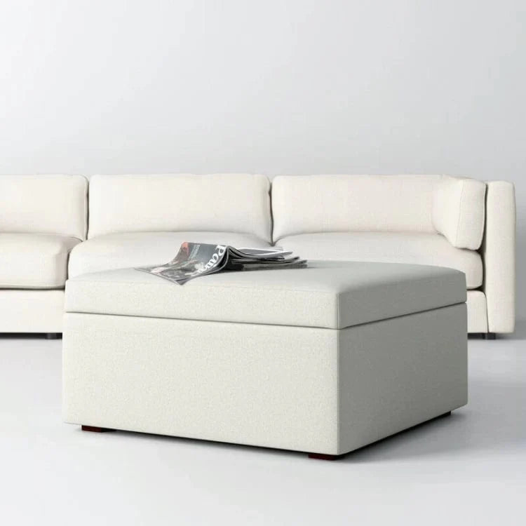White sectional sofa with a matching ottoman on a light gray background