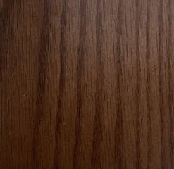 Close-up of a wooden surface with a dark brown color and visible grain pattern.