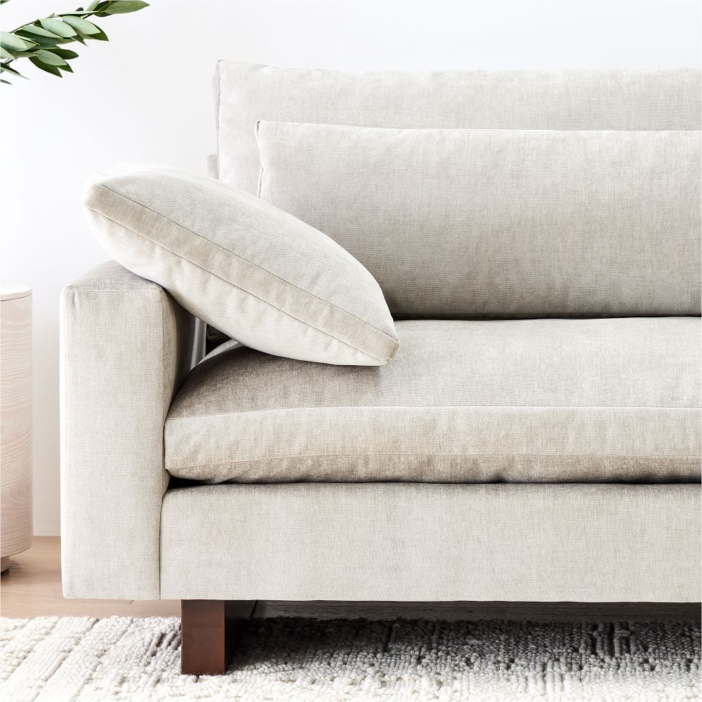 Beige sofa with a pillow in a minimalistic room setting