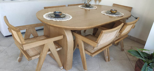 Wooden dining table with six chairs in a room setting.