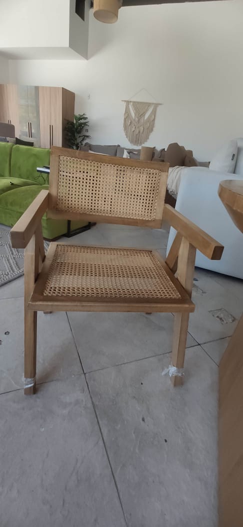 Wicker chair in a living room setting with a couch and coffee table.