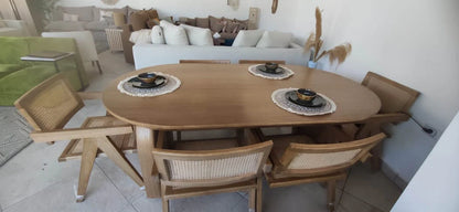 Wooden dining table with chairs in a living room setting