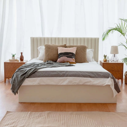 Neatly made bed with decorative pillows in a bright bedroom setting.