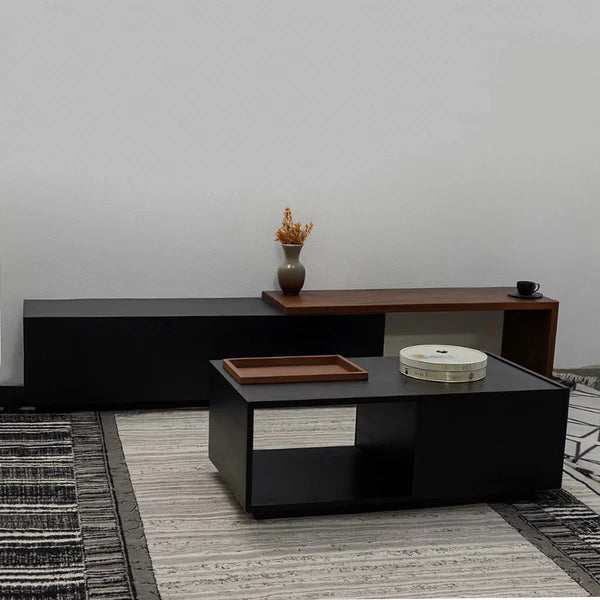 Modern living room with a black coffee table and wooden sideboard against a gray wall.