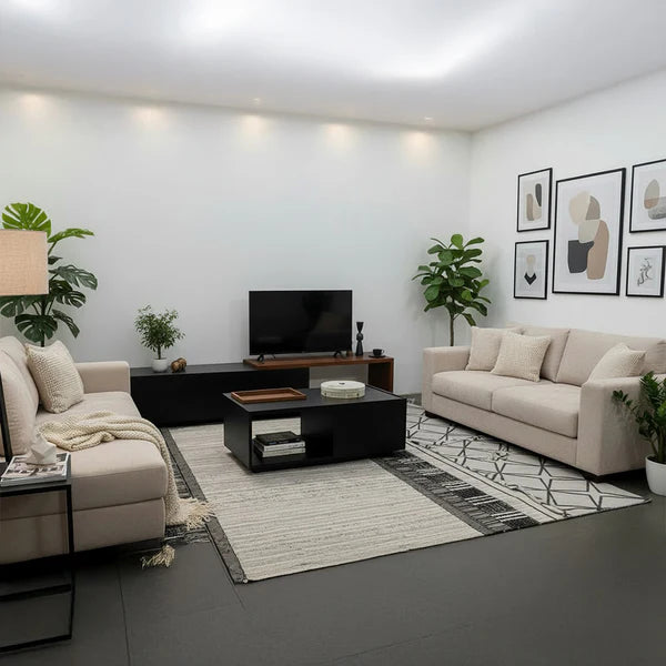 Modern living room with beige sofas, a TV stand, and decorative elements.