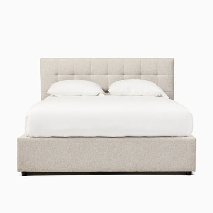 Beige upholstered bed with white bedding on a white background