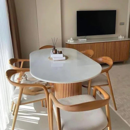 Dining area with a white oval table and wooden chairs in a modern living room.